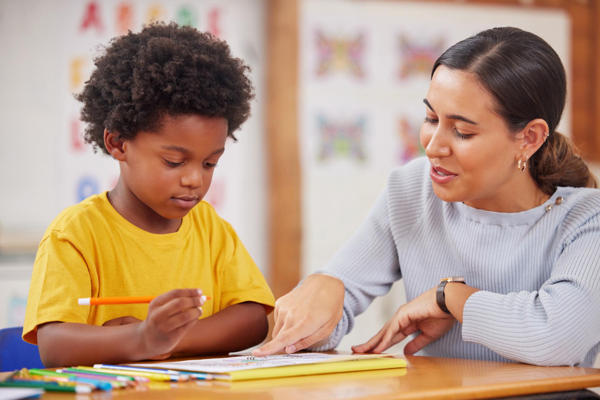 Shot of a female teacher assisting a preschool learner in her class