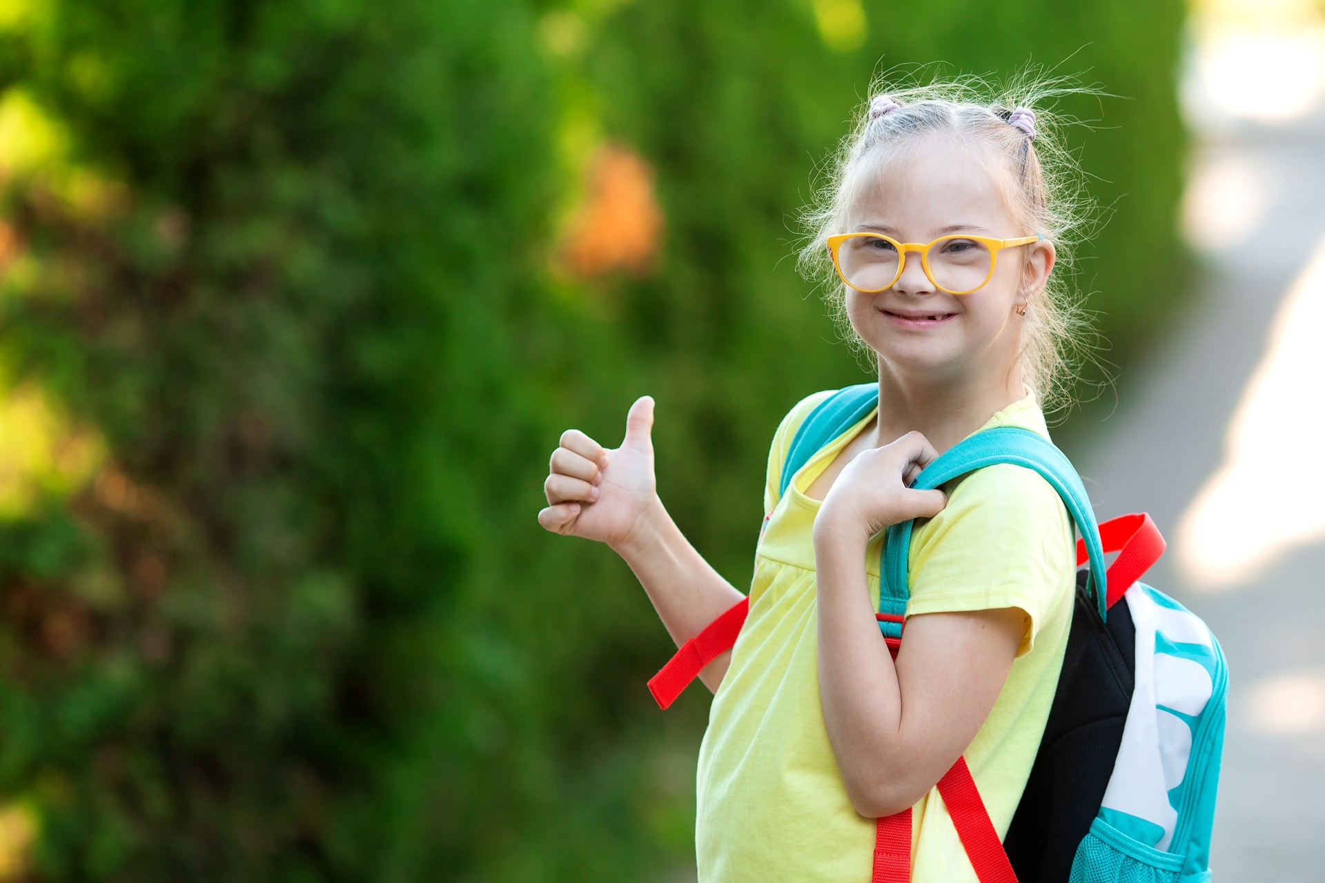 A girl with Down syndrome goes to school with a backpack